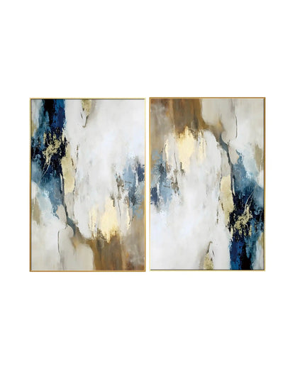 An abstract diptych painting featuring fluid, cloud-like patches of white, cream, and beige, contrasted by bold splashes of deep navy blue and textured metallic gold leaf accents throughout.